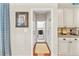 Hallway with a laundry room view, wooden floors, and neutral-colored walls at 3640 Ridgeway Ter, Suwanee, GA 30024