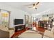 Open-concept living room features hardwood floors, modern furniture, and a view of the dining area at 3640 Ridgeway Ter, Suwanee, GA 30024