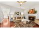 Cozy living room features a fireplace, hardwood floors, and a comfortable sectional sofa at 3640 Ridgeway Ter, Suwanee, GA 30024