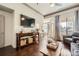 Open-concept living room with hardwood floors, a large screen TV, and balcony access at 3777 Peachtree Ne Rd # 1335, Atlanta, GA 30319