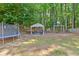 Green backyard featuring trampoline, basketball hoop, mature trees, and a shady gazebo seating area at 3798 Kirkwood Nw Run, Kennesaw, GA 30144