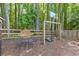 Outdoor backyard entertainment area with basketball hoop, swing set, and patio set nestled in a wooded setting at 3798 Kirkwood Nw Run, Kennesaw, GA 30144