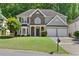 Traditional two-story home boasts a well-kept lawn, double garage, and inviting curb appeal at 3798 Kirkwood Nw Run, Kennesaw, GA 30144