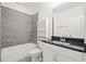 Bathroom with a shower-tub combo, gray tile surround, and black granite vanity at 4206 Townsend Ln, Atlanta, GA 30346