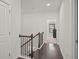 Hallway featuring hardwood floors and staircase with iron balusters, leading to bedrooms at 4206 Townsend Ln, Atlanta, GA 30346