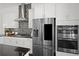 Modern kitchen features stainless steel refrigerator, double oven, granite counters and mosaic backsplash at 4206 Townsend Ln, Atlanta, GA 30346
