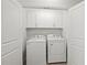 Convenient laundry room featuring side-by-side appliances, upper cabinets, and light colored walls at 4206 Townsend Ln, Atlanta, GA 30346