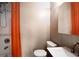 Tidy bathroom features a tiled shower with orange shower curtain at 1545 Montreat Sw Pl, Atlanta, GA 30311