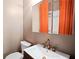 Updated bathroom featuring a modern sink, brushed gold fixtures and a bright orange shower curtain at 1545 Montreat Sw Pl, Atlanta, GA 30311