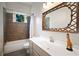 Charming bathroom featuring a unique mirror and a tiled shower with neutral decor at 1545 Montreat Sw Pl, Atlanta, GA 30311