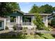 A cozy home with a green exterior, a charming front porch with white railings, and surrounding greenery at 1545 Montreat Sw Pl, Atlanta, GA 30311