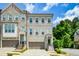 Beautiful townhome with a gray painted brick facade, two-car garage and charming architectural details at 2187 Elmont Se Way, Smyrna, GA 30080