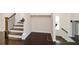 Hallway featuring dark hardwood floors, staircase with wooden banister and white walls at 2187 Elmont Se Way, Smyrna, GA 30080