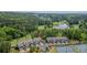 Aerial view of townhomes, tennis courts and a pond amid the wooded area creates an inviting community at 232 Heron Pointe Vw, Canton, GA 30114