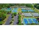 Aerial view showing tennis courts near residential buildings and parking areas, all surrounded by lush greenery at 232 Heron Pointe Vw, Canton, GA 30114