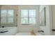 Spa-like bathroom featuring a soaking tub under a window with a view at 232 Heron Pointe Vw, Canton, GA 30114