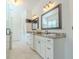 Bright bathroom featuring double vanity with granite countertops and dark framed mirrors at 232 Heron Pointe Vw, Canton, GA 30114