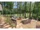 Cozy backyard fire pit area surrounded by mature trees and scenic golf course views at 232 Heron Pointe Vw, Canton, GA 30114