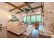 Comfortable living room with stone fireplace, beamed ceiling, hardwood floors, and access to the outdoor deck at 232 Heron Pointe Vw, Canton, GA 30114