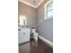 Chic powder room featuring stylish wallpaper, a white vanity, and a modern mirror at 232 Heron Pointe Vw, Canton, GA 30114