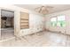Dilapidated bedroom with debris, damaged walls, and dirty tile flooring under a ceiling fan at 2322 Paces Ferry Se Rd, Smyrna, GA 30080