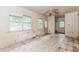 Condemned living room featuring two windows, a ceiling fan, and cracked tile flooring at 2322 Paces Ferry Se Rd, Smyrna, GA 30080