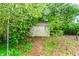 Weathered storage shed with double doors, nestled amidst lush greenery, providing extra outdoor space at 2322 Paces Ferry Se Rd, Smyrna, GA 30080
