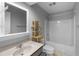Neutral colored bathroom features a tub with shower, vanity, and wooden shelving at 380 Kendrick Se Ave, Atlanta, GA 30315