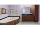 Bathroom with a corner tub, wooden vanity, and a dark countertop at 380 Kendrick Se Ave, Atlanta, GA 30315