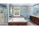 Bathroom with a large soaking tub, glass enclosed shower, and marble countertops at 380 Kendrick Se Ave, Atlanta, GA 30315