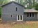 Back exterior of the home featuring neutral siding, white trim, and a cozy outdoor space at 486 Victoria Rd, Woodstock, GA 30189