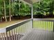 A view from the back porch to a tranquil wooded backyard complete with classic white railing at 486 Victoria Rd, Woodstock, GA 30189