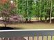 Picture of the spacious, wooded backyard with a charming red maple tree and classic white railing at 486 Victoria Rd, Woodstock, GA 30189