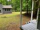 View from back porch shows a spacious, wooded backyard and the home's back exterior at 486 Victoria Rd, Woodstock, GA 30189
