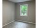 Bright bedroom with neutral walls and carpet, featuring a window view of lush greenery at 486 Victoria Rd, Woodstock, GA 30189