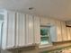 A view of the kitchen cabinets from inside the kitchen, with a window that overlooks the backyard at 486 Victoria Rd, Woodstock, GA 30189