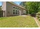 Exterior of home with a walk-out patio and large windows overlooking a grassy backyard at 1125 Harvest Brook Way, Lawrenceville, GA 30043