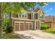 Charming two-story home featuring a stone facade, attached two-car garage, and well-manicured landscaping at 1125 Harvest Brook Way, Lawrenceville, GA 30043