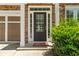 Close-up of the front door, complemented by stone accents and manicured greenery at 1125 Harvest Brook Way, Lawrenceville, GA 30043