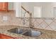 Close-up of granite countertops and stainless steel sink with modern faucet and tiled backsplash at 1125 Harvest Brook Way, Lawrenceville, GA 30043