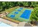 Overhead view of well-maintained tennis courts in a green surrounding with an adjacent pool at 1125 Harvest Brook Way, Lawrenceville, GA 30043