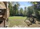 Large backyard with lush green lawn, swing set, patio, and wooded perimeter at 1493 Martin Nash Sw Rd, Lilburn, GA 30047