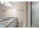 Bright bathroom featuring granite countertop, white cabinetry, framed mirror and tiled shower at 1493 Martin Nash Sw Rd, Lilburn, GA 30047