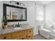 Bathroom with modern light fixture, framed mirror, and sink with granite countertop at 1493 Martin Nash Sw Rd, Lilburn, GA 30047