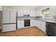 Well-lit kitchen features white cabinets, granite countertops, and stainless steel appliances at 1493 Martin Nash Sw Rd, Lilburn, GA 30047
