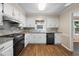 Modern kitchen with white cabinets, stainless appliances, and stylish countertops at 1493 Martin Nash Sw Rd, Lilburn, GA 30047