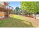 Expansive backyard featuring a lush lawn, mature trees, and a charming deck perfect for outdoor entertaining at 1730 Millhouse Run, Marietta, GA 30066