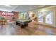 Basement featuring a pool table, wood floors, exposed brick, and outdoor access at 1730 Millhouse Run, Marietta, GA 30066