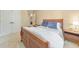 Bedroom with a wooden sleigh bed, neutral carpet and walls, double door closet, and night stand with a lamp at 1730 Millhouse Run, Marietta, GA 30066