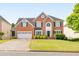 Elegant two-story brick home with a manicured lawn, attached garage, and classic architectural details at 1730 Millhouse Run, Marietta, GA 30066